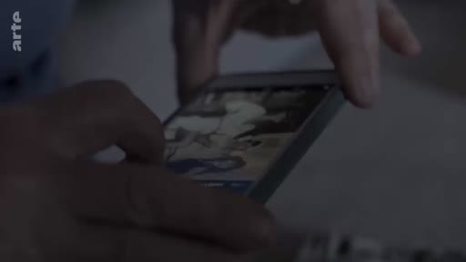 Une personne consulte une photographie numérique sur un smartphone, illustrant le partage de souvenirs familiaux ou la transmission intergénérationnelle.