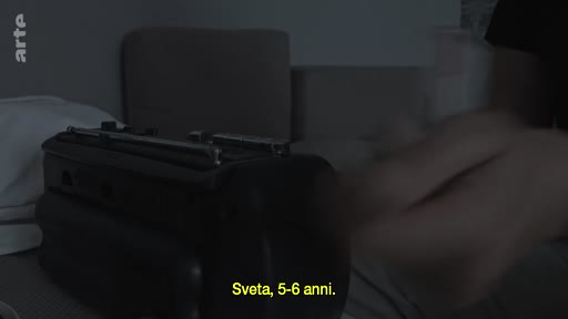 Un magnétophone à cassettes vintage est filmé en gros plan, accompagné d'une légende indiquant 'Sveta, 5-6 anni', suggérant une écoute d'archives personnelles ou familiales.