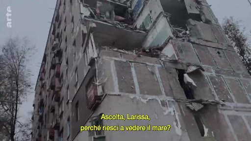 Un immeuble d'habitation partiellement détruit par des frappes militaires, illustrant les conséquences de la guerre en Ukraine. Le sous-titre en italien interroge sur la visibilité de la mer depuis les décombres.