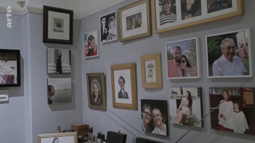 Un mur intérieur orné d'une collection de portraits photographiques et de souvenirs de famille, illustrant une atmosphère personnelle et intime dans un foyer londonien.