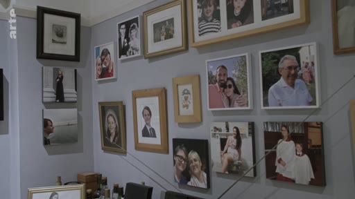 Un mur intérieur orné d'une collection de photographies de famille encadrées, illustrant une atmosphère personnelle et intime dans un environnement londonien.