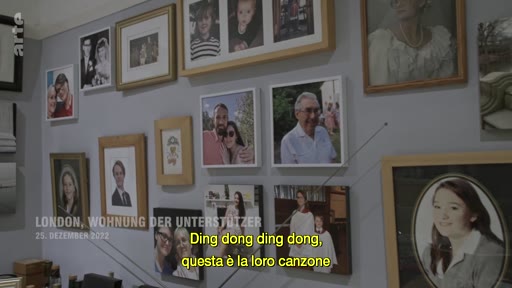 Un mur couvert de portraits de famille et de souvenirs photographiques dans un appartement à Londres, le 25 décembre 2012. L'image illustre un environnement domestique et personnel, avec une légende indiquant 'LONDON, WOHNUNG DER UNTERSTÜTZER'.