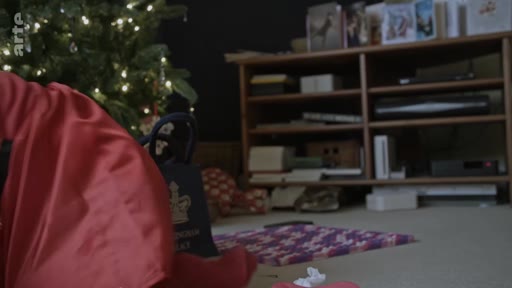 Un passeport britannique est posé sur le sol à côté d'un sapin de Noël décoré, dans le cadre d'une séquence sur la famille royale et le discours du roi.