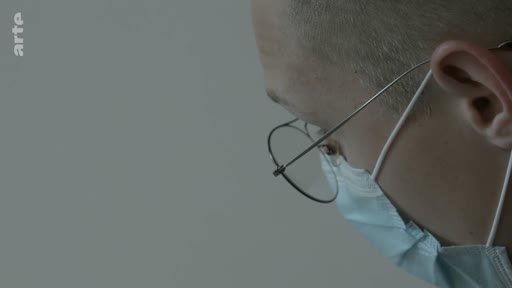 Un médecin ou professionnel de santé, portant un masque chirurgical et des lunettes, est filmé en gros plan lors d'une consultation médicale. Le logo de la chaîne Arte est visible dans le coin supérieur gauche.