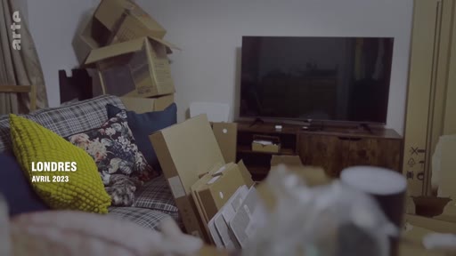 Vue intérieure d'un salon rempli de cartons de déménagement à Londres en avril 2023, illustrant une situation de précarité ou de transition résidentielle.