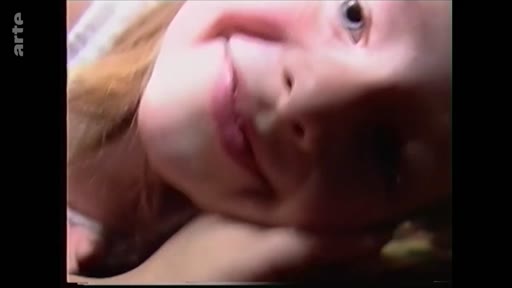 Gros plan sur le visage d'une jeune fille souriante, extrait d'archives personnelles illustrant des souvenirs d'enfance à Marioupol.