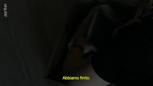 Une personne prépare ses affaires pour un voyage, illustrant le moment où elle termine de ranger ses effets personnels. Le sous-titre italien « Abbiamo finito » souligne la fin de l'action de préparation.