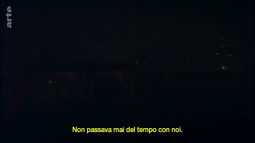 Un sous-titre en italien « Non passava mai del tempo con noi. » apparaît sur un écran sombre, illustrant une séquence de dialogue ou de narration.
