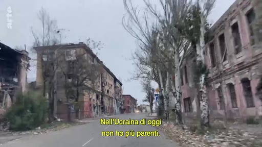 Vue d'une rue en Ukraine montrant des bâtiments résidentiels gravement endommagés et en ruines suite aux combats. Le sous-titre indique le témoignage d'une personne ayant perdu ses proches dans le conflit actuel.