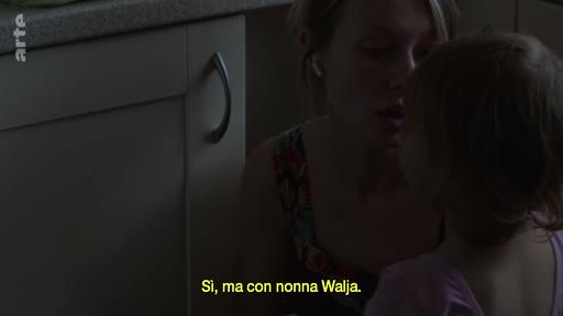 Une mère et sa jeune fille ont une conversation intime dans une cuisine, avec un sous-titre en italien mentionnant 'nonna Walja'.