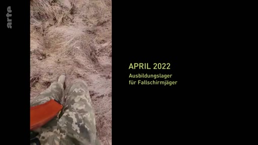 Un soldat portant un uniforme de camouflage et équipé d'une arme marche dans un champ herbeux lors d'un camp d'entraînement pour parachutistes en avril 2022. L'image est accompagnée d'un texte informatif en allemand précisant la date et la nature de l'exercice militaire.