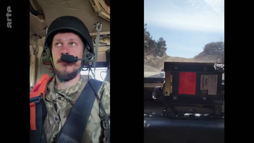 Un soldat ukrainien en tenue de camouflage et casque militaire est filmé à l'intérieur d'un véhicule blindé lors d'un entraînement. La vue montre le conducteur et la route devant lui, illustrant la formation militaire en cours.