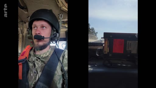 Un soldat ukrainien en tenue de combat et équipé d'un casque et d'un micro est filmé à l'intérieur d'un véhicule militaire lors d'un entraînement. La scène montre le militaire en gros plan, avec une vue sur l'équipement technique du véhicule à côté de lui.
