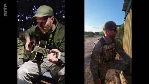 Un soldat ukrainien en tenue de camouflage joue de la guitare acoustique dans un campement en forêt, illustrant le quotidien des militaires sur le front. La scène montre des moments de détente et de vie quotidienne des troupes ukrainiennes.