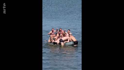 Des soldats russes en maillot de bain s'amusent et se baignent ensemble sur un canot pneumatique lors d'un moment de détente, illustrant la vie quotidienne et la camaraderie au sein des troupes.