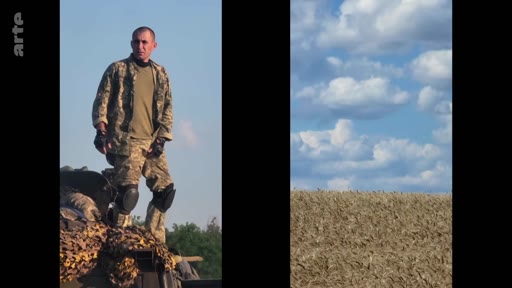 Un soldat ukrainien en tenue de camouflage et genouillères est debout sur un véhicule blindé dans un champ, illustrant le conflit en Ukraine.