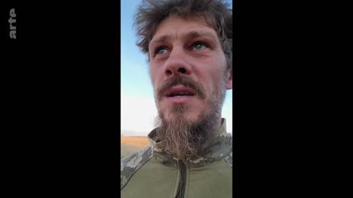 Un soldat ukrainien en tenue de camouflage s'exprime face caméra, probablement depuis le front, dans le cadre d'un reportage sur le conflit en Ukraine.