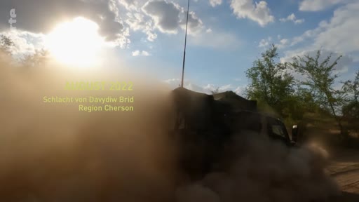 Un véhicule militaire circule sur un terrain poussiéreux dans la région de Kherson lors de la bataille de Davydiv Brid en 2022. Cette image illustre les opérations militaires en Ukraine.