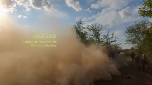 Des soldats ukrainiens avancent sur le terrain lors de la bataille de Davydiv Brid dans la région de Kherson en août 2022, dans un environnement marqué par la poussière et les combats.