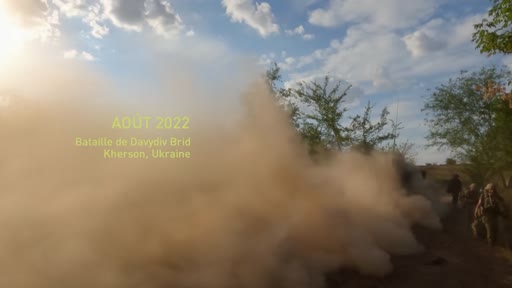 Des soldats ukrainiens avancent sur le terrain lors de la bataille de Davydiv Brid dans la région de Kherson en août 2022, dans un contexte de combats intenses marqués par d'épais nuages de poussière.