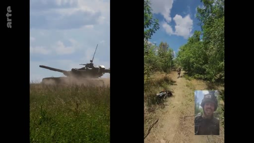 Un soldat ukrainien en tenue de combat filme un char de combat en mouvement dans une zone boisée lors d'une opération sur le front. L'image montre une vue en écran divisé avec un char à gauche et le soldat en gros plan à droite.