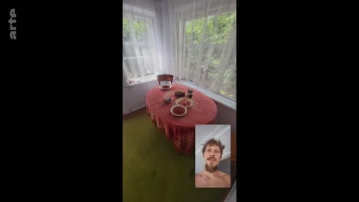 Un homme barbu apparaît en médaillon lors d'un appel vidéo, montrant une pièce lumineuse avec une table recouverte d'une nappe rouge et des plats, illustrant le maintien des liens familiaux malgré le contexte de conflit.