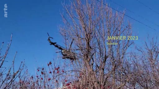 Un hélicoptère de combat survole une zone boisée près de Soledar, en Ukraine, en janvier 2023, dans le contexte de la guerre en Ukraine. L'image illustre les conditions hivernales sur le front.