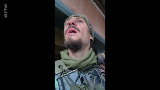Un soldat ukrainien en uniforme militaire et bonnet de camouflage observe le ciel, illustrant la tension et la menace constante du conflit en Ukraine.