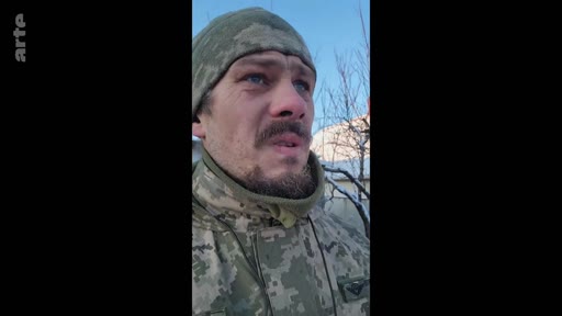 Un soldat ukrainien en tenue de camouflage et bonnet porte un témoignage face caméra, probablement depuis le front, dans le cadre d'un reportage sur la guerre en Ukraine.
