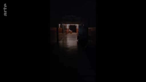 Vue en contre-plongée d'un couloir sombre et désert dans un hôpital militaire, illustrant les conditions de soins et de convalescence.