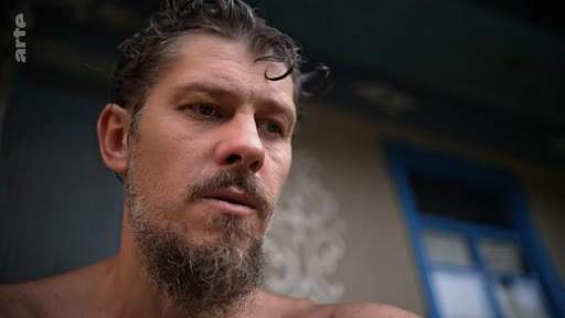 Gros plan sur un homme barbu à l'air pensif et mélancolique, illustrant une séquence sur le voyage vers la libération personnelle.