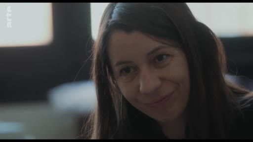 Une femme, probablement une mère, affiche un sourire bienveillant lors d'une conversation intime avec son fils sur les changements de vie.