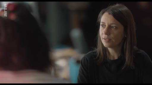 Une femme s'exprime lors d'une discussion en groupe, probablement dans le cadre d'un entretien ou d'une réunion de travail.