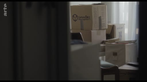 Des cartons de déménagement empilés dans une pièce, évoquant le processus de déménagement ou de changement de domicile.