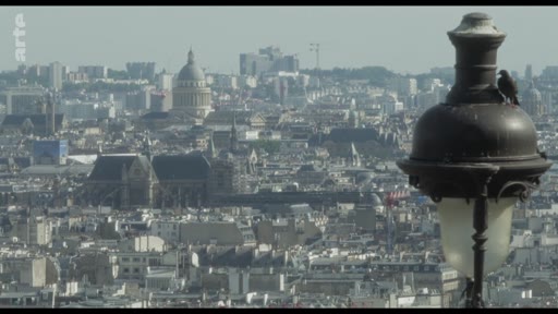 Vue en plongée sur les toits de Paris, mettant en évidence le dôme du Panthéon dans le paysage urbain, avec un réverbère parisien classique au premier plan.