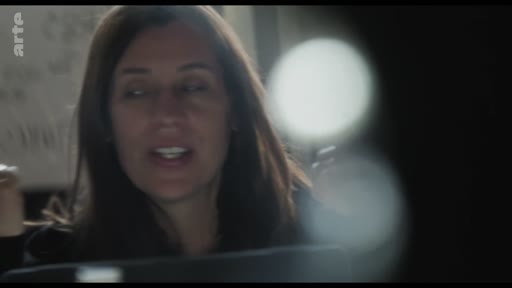 Une femme s'exprime face caméra lors d'un débriefing dans un espace de production, avec le logo de la chaîne Arte visible en haut à gauche.