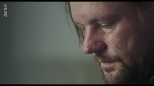 Gros plan sur le visage d'un homme exprimant une émotion de vulnérabilité ou de tristesse lors d'une discussion.