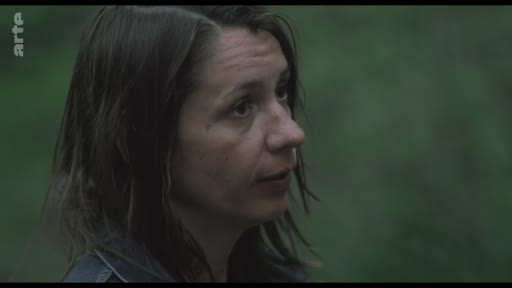 Une femme est filmée en gros plan dans un environnement extérieur, probablement lors d'un tournage ou d'une interview.