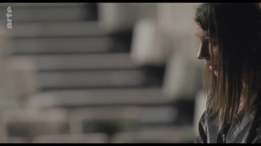 Gros plan sur une femme lors d'une discussion sur un collègue, dans une séquence de type entretien.