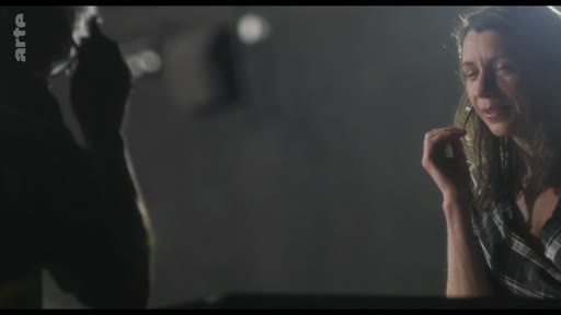 Une actrice en pleine répétition, capturée dans une lumière tamisée lors d'une séance de travail artistique. L'image souligne l'intensité de l'interprétation et le cadre intimiste d'une salle de répétition.