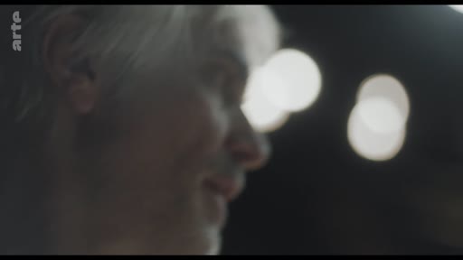 Un homme aux cheveux gris, filmé en gros plan, s'exprime lors d'un entretien télévisé sur la chaîne Arte.