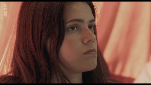 Une jeune femme aux cheveux roux est filmée en gros plan alors qu'elle participe à une discussion en classe sur le thème des traumatismes.