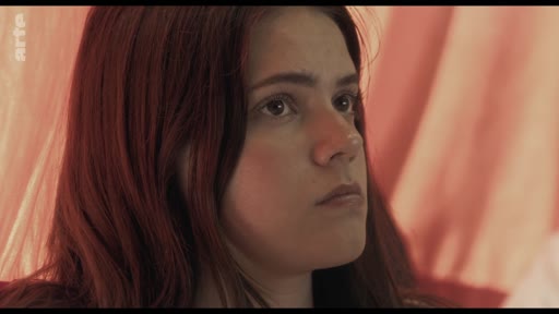 Une jeune femme aux cheveux roux écoute avec attention lors d'une discussion en classe portant sur le thème des traumatismes.