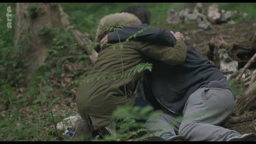 Deux personnes se réconfortent en s'enlaçant dans un environnement forestier, illustrant un moment de soutien émotionnel en pleine nature.