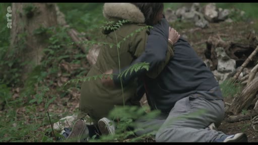 Deux personnes en tenue décontractée s'enlacent dans un environnement forestier, illustrant un moment de réconfort en pleine nature.